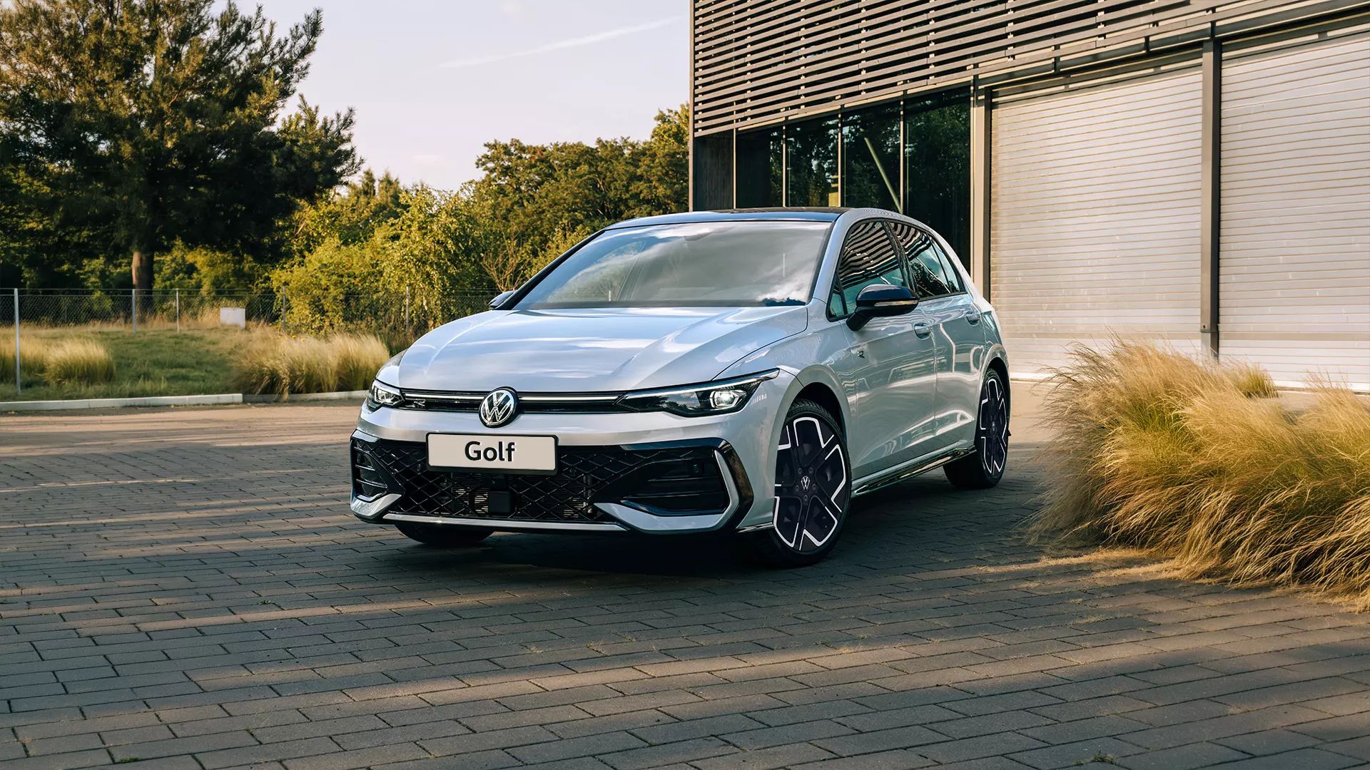 Stříbrný Volkswagen Golf zaparkovaný před budovou
